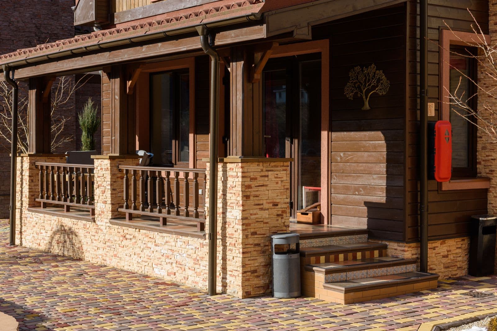 Beautiful wooden house exterior with stone accents and a cozy porch in bright daylight.